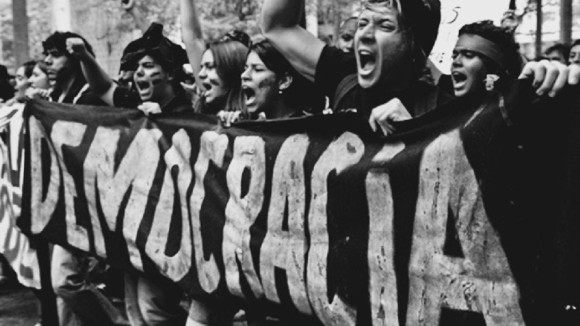 Jovens da América Latina com faixa escrito: Democracia